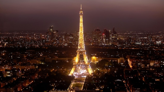 La tour Eiffel, illuminée en soirée, trône au coeur de la ville.