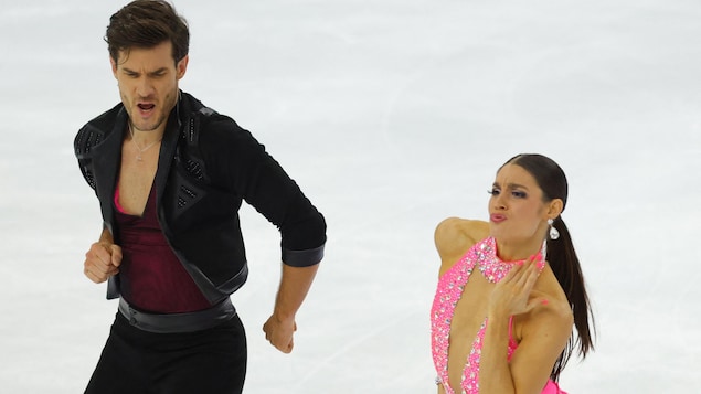 Un couple de patineurs dansent avec attitude sur la glace.