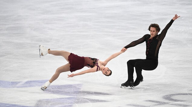 Un couple effectue une figure lors d'une compétition de patinage artistique.