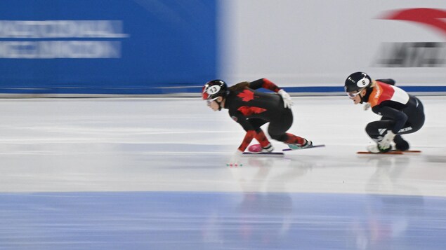 Danae Blais, le bras droit derrière le dos, patine devant son adversaire des Pays-Bas.