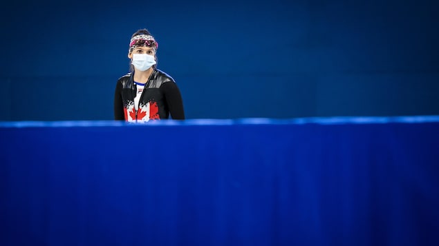 Une patineuse avec un masque près d'un anneau de glace