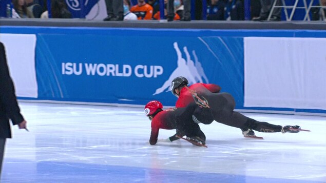 Deux patineurs de vitesse courte piste s'effondrent sur la glace pendant une course.
