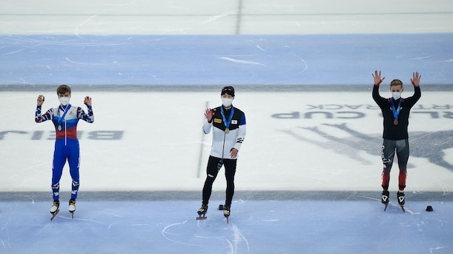 Des patineurs saluent la foule avec leur médaille au cou.