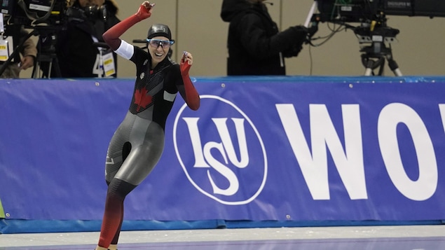 Elle lève les bras après sa victoire au 3000 m.