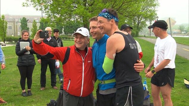 Patrick Charlebois (à droite) prend une photo avec des coureurs venus l'encourager à Montréal. Patrick Charlebois (à droite) prend une photo avec des coureurs venus l'encourager à Montréal.