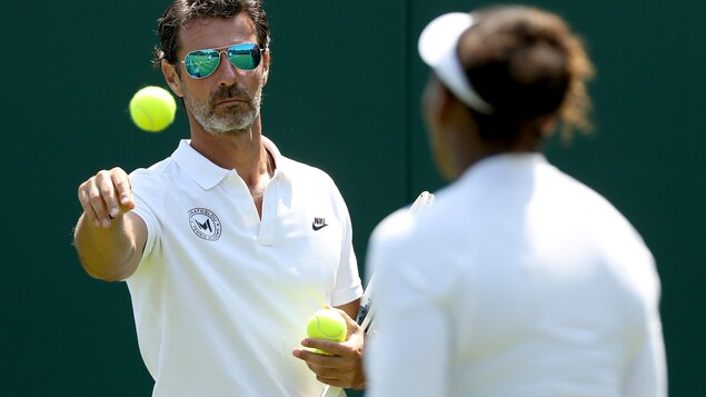 L'entraîneur lance une balle à Serena Williams. L'entraîneur lance une balle à Serena Williams.