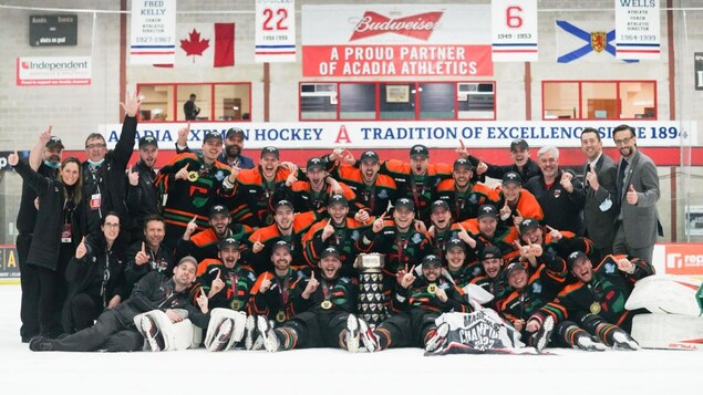 L'équipe des Patriotes de l’Université du Québec à Trois-Rivières est regroupée autour d'un trophée après la conquête du titre canadien.