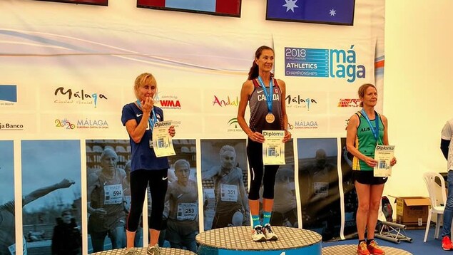 Le podium de la course de 800 m, catégorie 60-64 ans, aux Mondiaux d'athlétisme des maîtres. Au centre, médaillée d'or, Patty Blanchard; à gauche, Lesley Hinz (argent); à droite, Deborah Drennan. Chacune a son certificat souvenir de la course. Le podium de la course de 800 m, catégorie 60-64 ans, aux Mondiaux d'athlétisme des maîtres. Au centre, médaillée d'or, Patty Blanchard; à gauche, Lesley Hinz (argent); à droite, Deborah Drennan. Chacune a son certificat souvenir de la course.