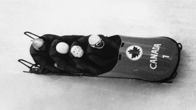 La photo en noir et blanc les montre dans un bobsleigh.