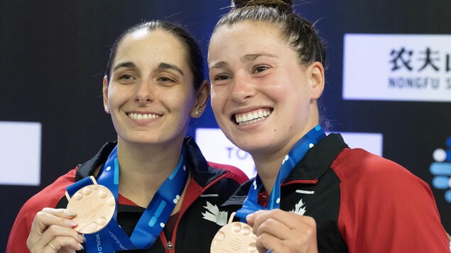 Mia Vallée et Pamela Ware présentent leurs médailles de bronze aux photographes.