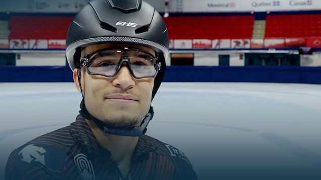 Un patineur avec son casque et ses lunettes près de la glace