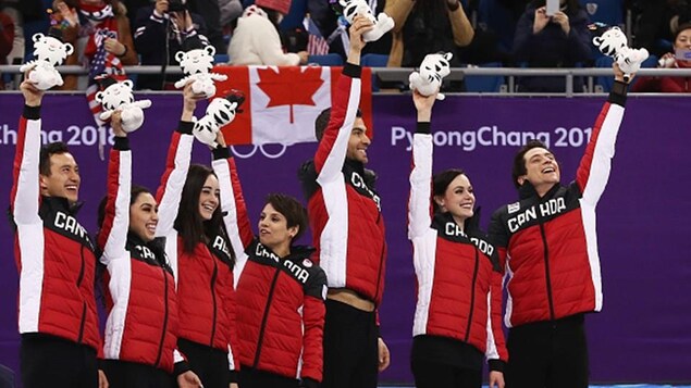 Meagan Duhamel et Eric Radford (au centre) avec des peluches sur le podium de l'épreuve par équipe à Pyeongchang Meagan Duhamel et Eric Radford (au centre) avec des peluches sur le podium de l'épreuve par équipe à Pyeongchang