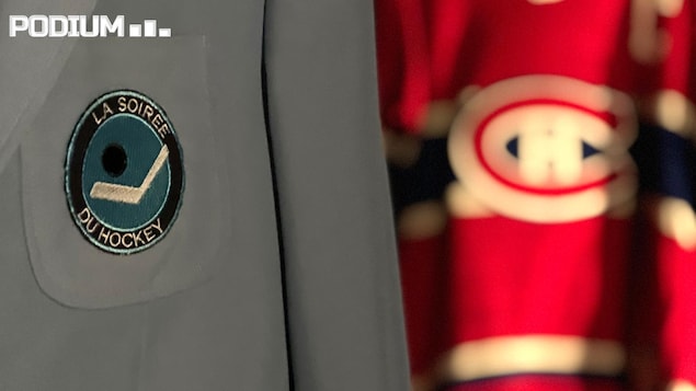 Un veston bleu poudre avec le logo de la Soirée du hockey à côté duquel on voit un chandail rouge du Canadien de Montréal