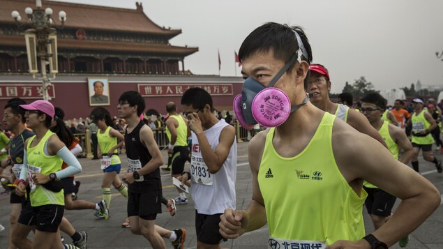 Un homme masqué pour se protéger de la pollution participe au marathon de Pékin, disputé en septembre Un homme masqué pour se protéger de la pollution participe au marathon de Pékin, disputé en septembre