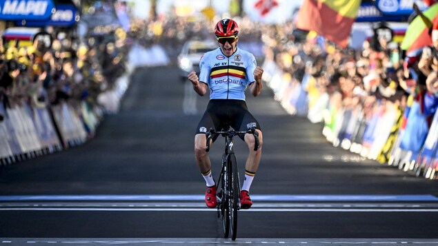 Le cycliste belge, avec un casque rouge et un maillot aux couleurs de son pays, serre les poings alors qu'il franchit le fil d'arrivée. 