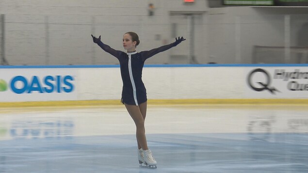 Rose en pleine prestation sur la glace les bras ouverts