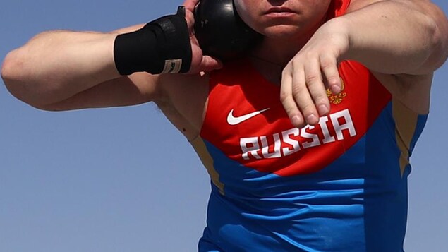 Un athlète russe s'apprête à lancer son poids.