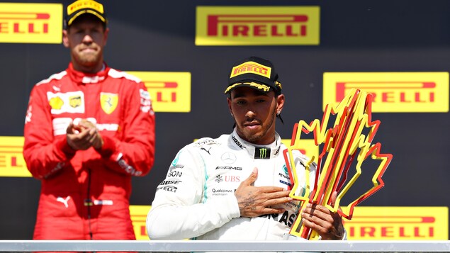Sebastian Vettel (à gauche) applaudit le gagnant du Grand Prix du Canada, Lewis Hamilton.
