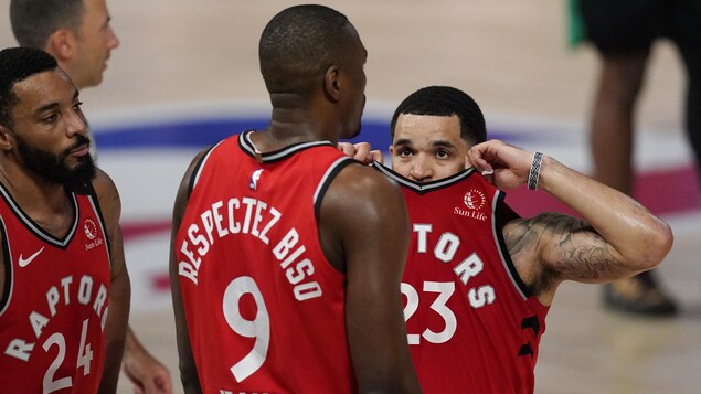 Fred VanVleet, visagé caché derrière le col de son maillot, regarde Serge Ibaka.