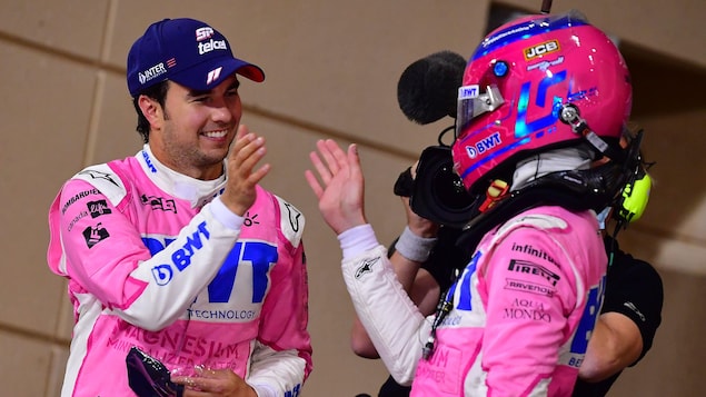 Deux pilotes de course se tapent la main pour se féliciter.