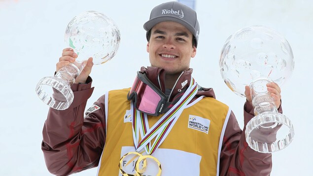 Le Canadien Mikaël Kingsbury soulève ses deux globes de cristal à titre de champion du classement des bosses et du classement général. Le Canadien Mikaël Kingsbury soulève ses deux globes de cristal à titre de champion du classement des bosses et du classement général.