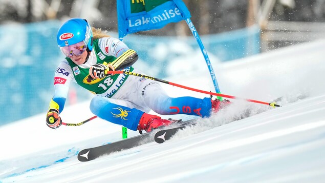 Une skieuse alpine garde sa position lors d'un virage serré.