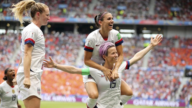 Alex Morgan saute sur les épaules de Megan Rapinoe (à droite) pour célébrer le but de cette dernière en finale de la Coupe du monde entre les Américaines et les Néerlandaises.