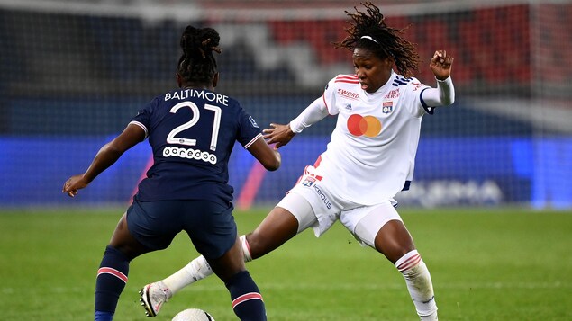 Elle tente de mettre le pied sur le ballon devant une adversaire.