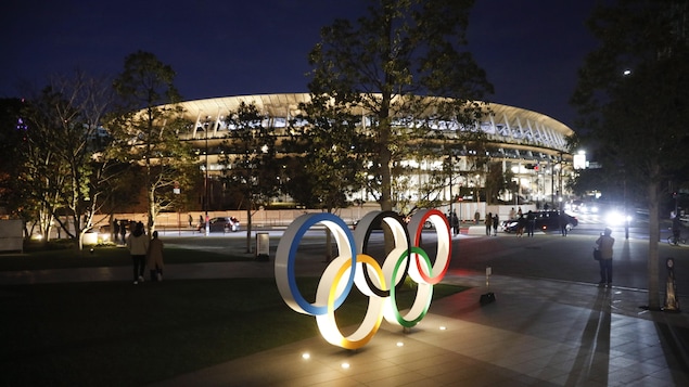 Les anneaux olympiques illuminés devant le stade de Tokyo inauguré dimanche le 15 décembre.