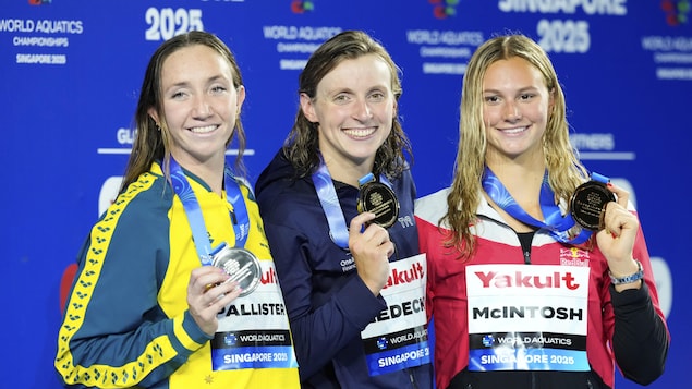 Trois nageuses médaillées au 800 m style libre au championnat du monde de sports aquatiques montrent leurs médailles.