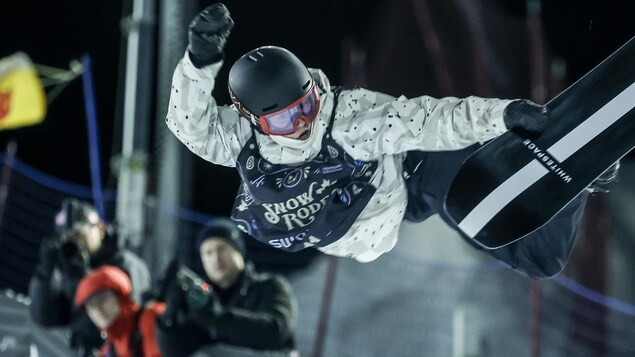 Elizabeth Hosking tient sa planche d'une main dans les airs.