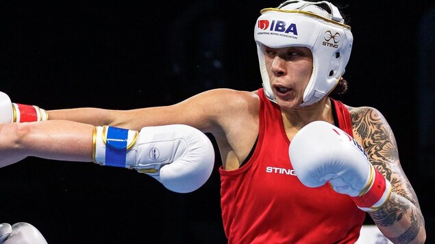 Une boxeuse en rouge esquive le coup d'une adversaire