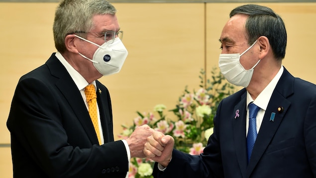 Deux hommes masqués se saluent en se cognant les poings fermés.