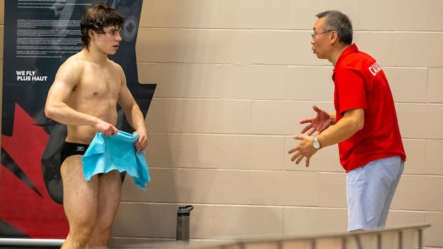 L'entraîneur Hui Tong donne ses directives au plongeur Thomas Ciprick, près de la piscine.
