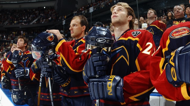 Les joueurs des Thrashers d'Atlanta se tiennent debout lors d'une cérémonie en l'honneur de Dan Snyder. Les joueurs des Thrashers d'Atlanta se tiennent debout lors d'une cérémonie en l'honneur de Dan Snyder.