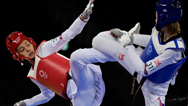 Deux taekwondoïstes s'affrontent lors d'un combat.