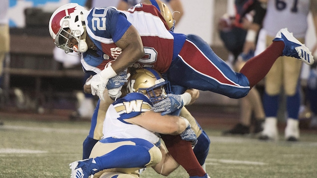 Tyrell Sutton est freiné par Adam Bighill, des Blue Bombers de Winnipeg Tyrell Sutton est freiné par Adam Bighill, des Blue Bombers de Winnipeg