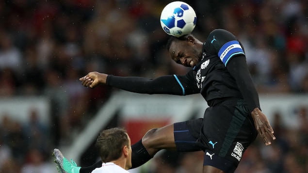 Usain Bolt fait une tête pendant un match de démonstration au profit de l'UNICEF en juin 2018 Usain Bolt fait une tête pendant un match de démonstration au profit de l'UNICEF en juin 2018