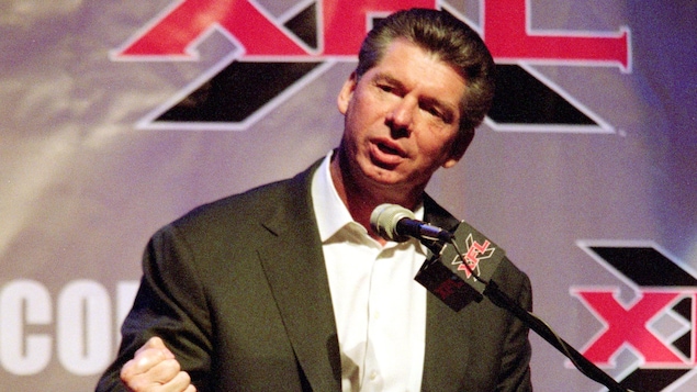 Vince McMahon en conférence de presse, devant un lutrin