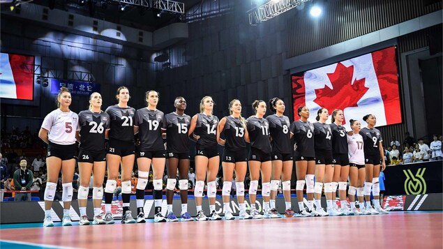 Les joueuses de la formation canadienne sont les unes à côté des autres pendant l'hymne national du Canada.