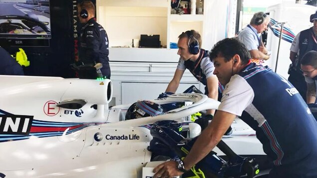 Le personnel de l'équipe Williams recule la voiture de Lance Stroll dans le garage. Le personnel de l'équipe Williams recule la voiture de Lance Stroll dans le garage.