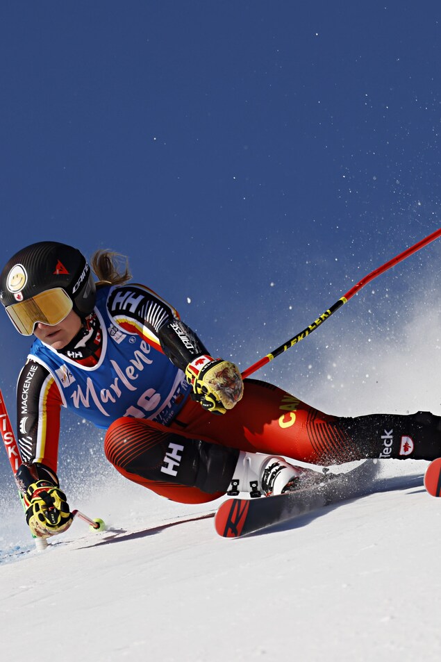 Une skieuse passe une porte dans une épreuve de vitesse.  