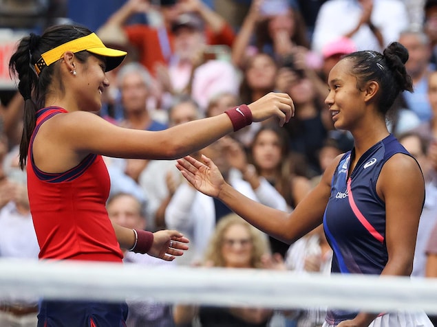 Deux femmes se  font l'accolade sur un terrain de tennis.