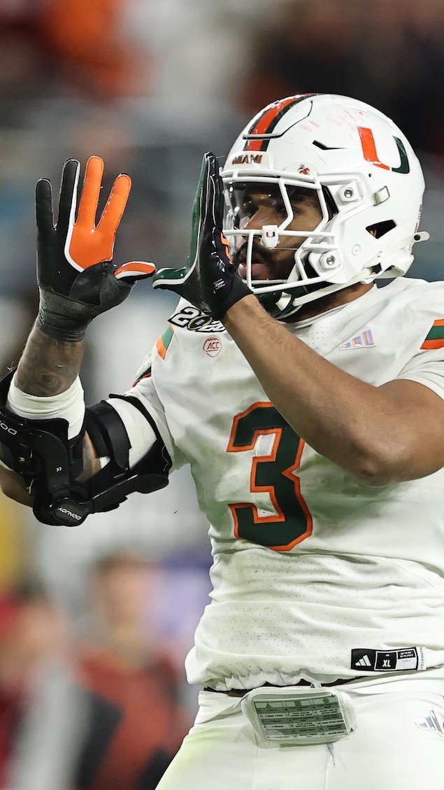 Un joueur de football fait un U avec ses mains après avoir plaqué un adversaire.