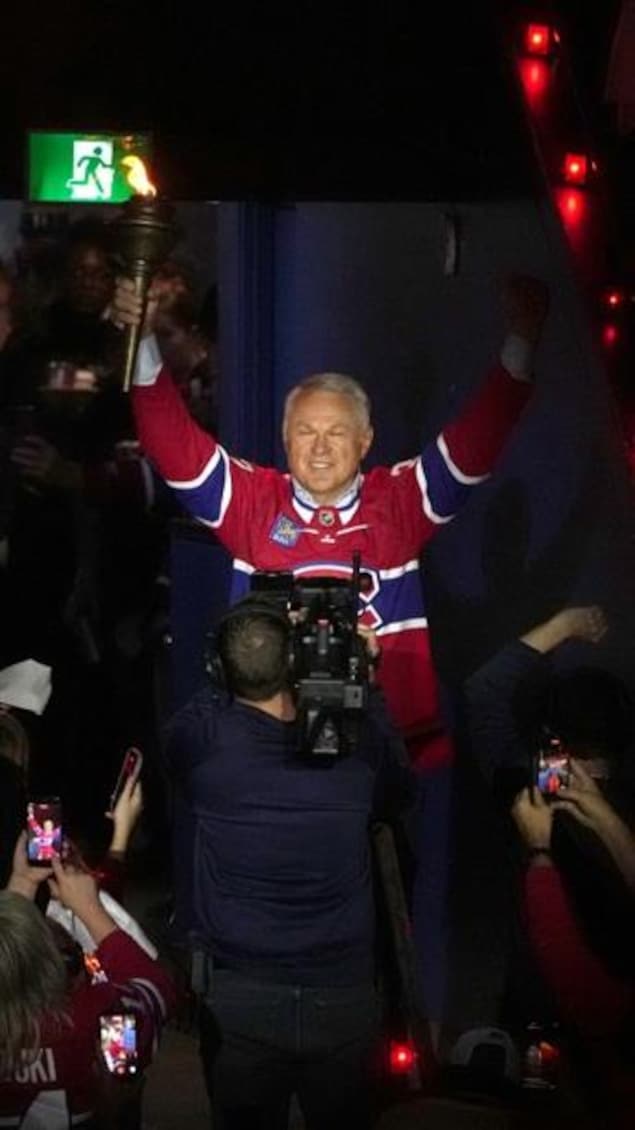 Claude Lemieux tient le flambeau et salue la foule en entrant dans le Centre Bell.