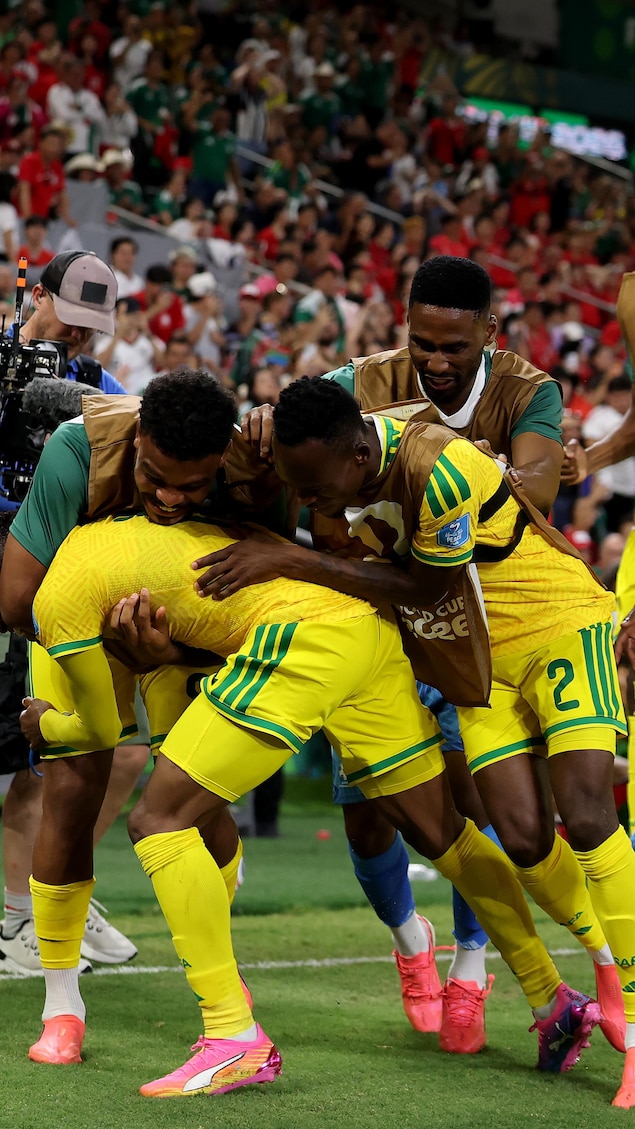 Des joueurs de soccer célèbrent un but.