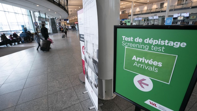 Une affiche pointant vers les tests de dépistage à l'aéroport Trudeau de Montréal.