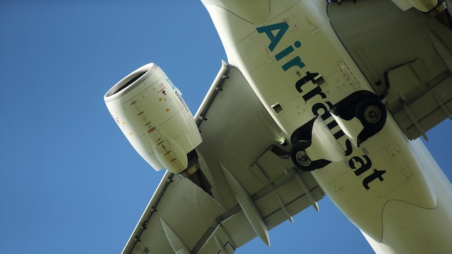 Une vue du dessous d'un avion dans le ciel.