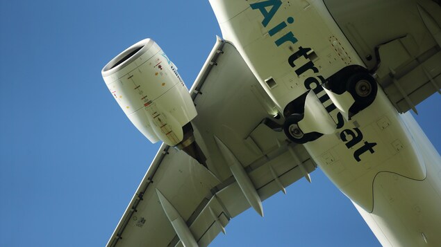 Le dessous d'un avion d'Air Transat dans le ciel.