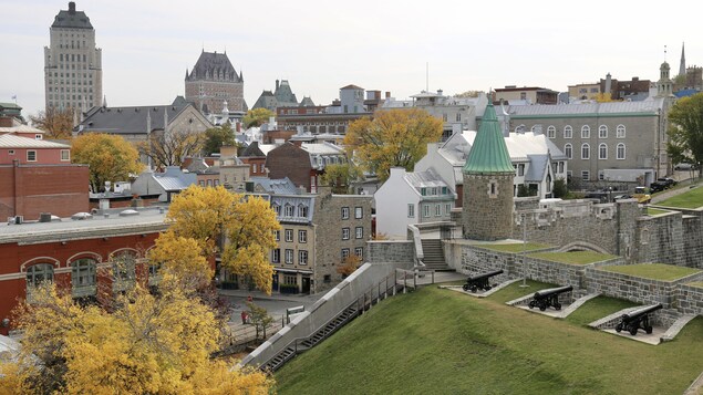 Vue sur le Vieux-Québec et ses principaux bâtiments, à l'avant-plan il y a une partie des murs avec des canons.
